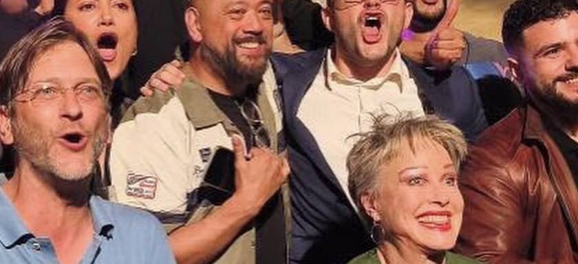 Comedians celebrating together on stage at Madrid Comedy Festival, wide crop