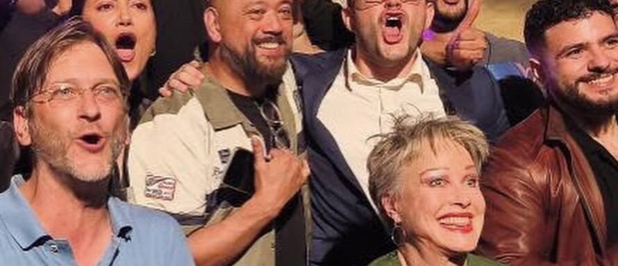 Comedians celebrating together on stage at Madrid Comedy Festival, wide crop
