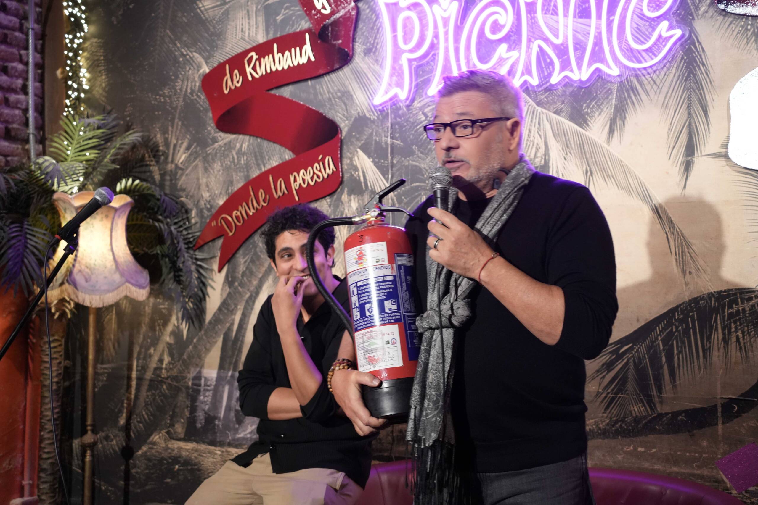 Dzimis Tapas on stage at Picnic Madrid, holding a comedy prop during a Madrid Comedy Festival show