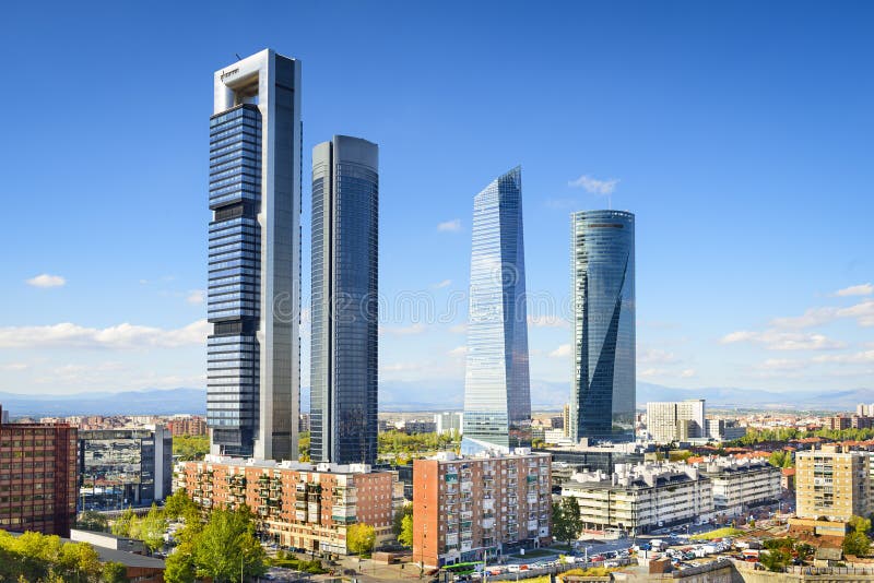 The Cuatro Torres skyscrapers in Madrid against a blue sky
