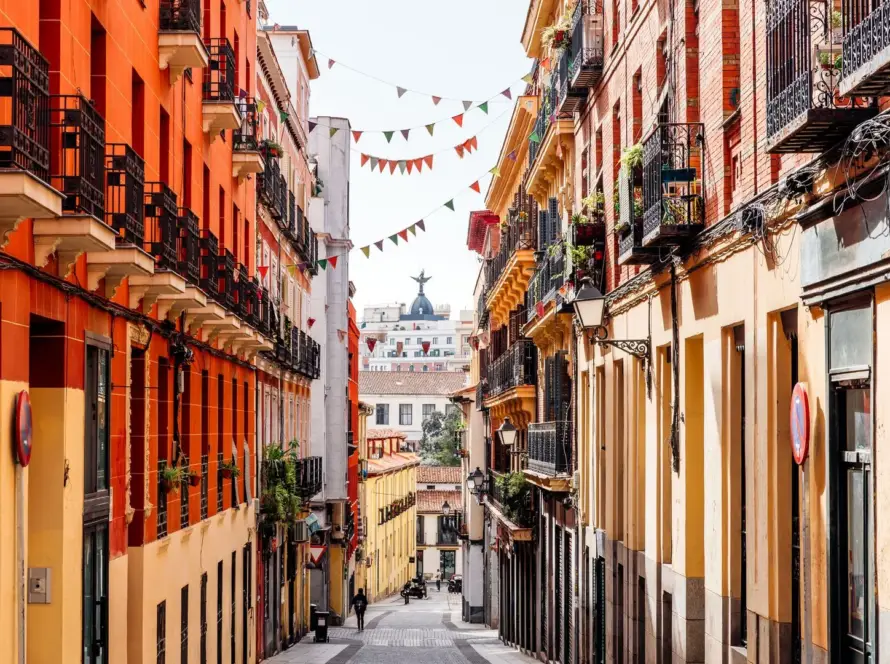 A narrow street lined with tall, colourful buildings in Malasaña, Madrid