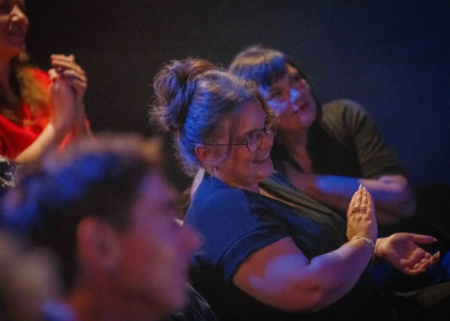 Audience members laughing and clapping during a Madrid Comedy Festival show
