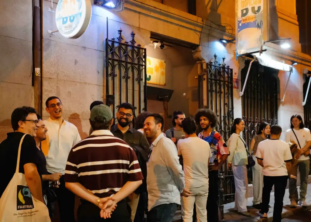 People gathered in the street outside a Madrid Comedy Festival venue at night