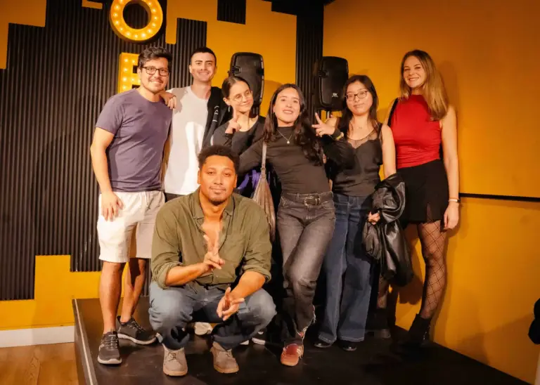 A group of comedians posing together on stage after a show