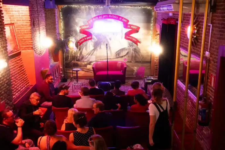 Audience in the red armchairs at Picnic for the Opening Gala, with the neon Picnic sign over the stage