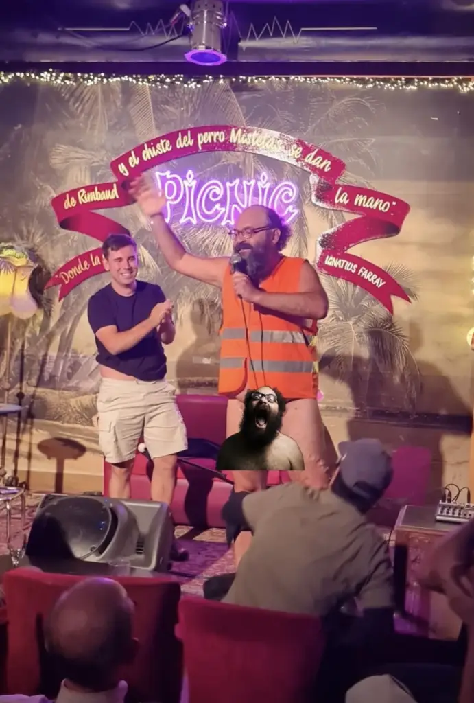 Two comedians on stage at Picnic during Madrid Comedy Festival, one in an orange hi-vis vest waving to the crowd