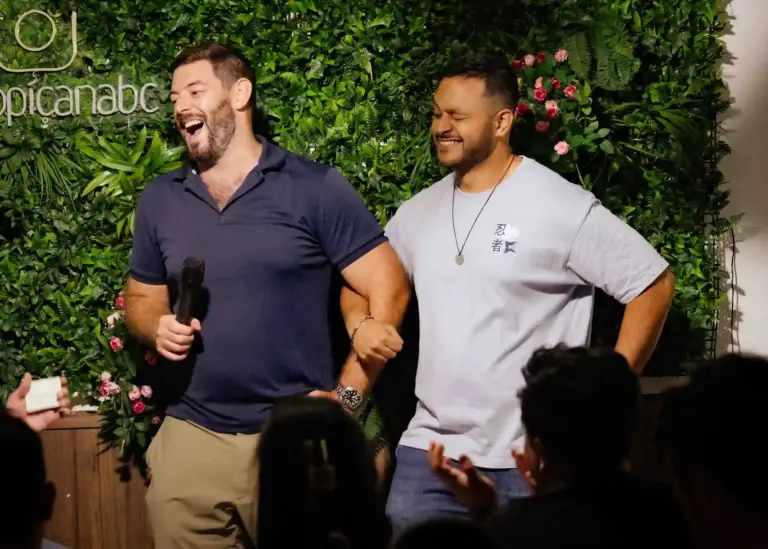 Two comedians laughing together on stage at Tropicana